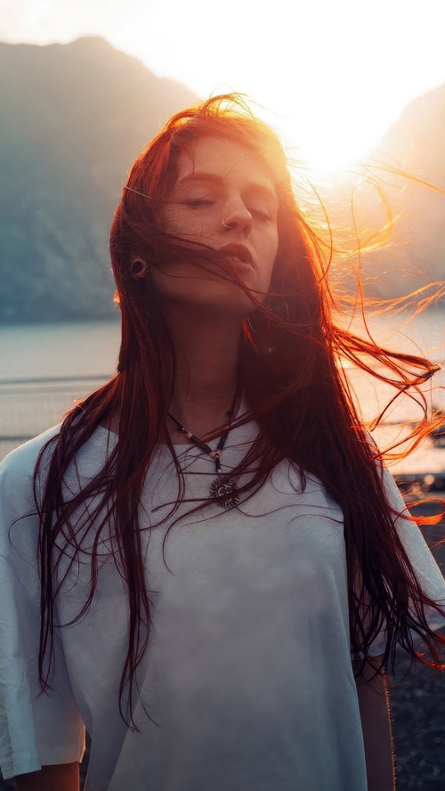 Girl with red hair in sunlight outdoors