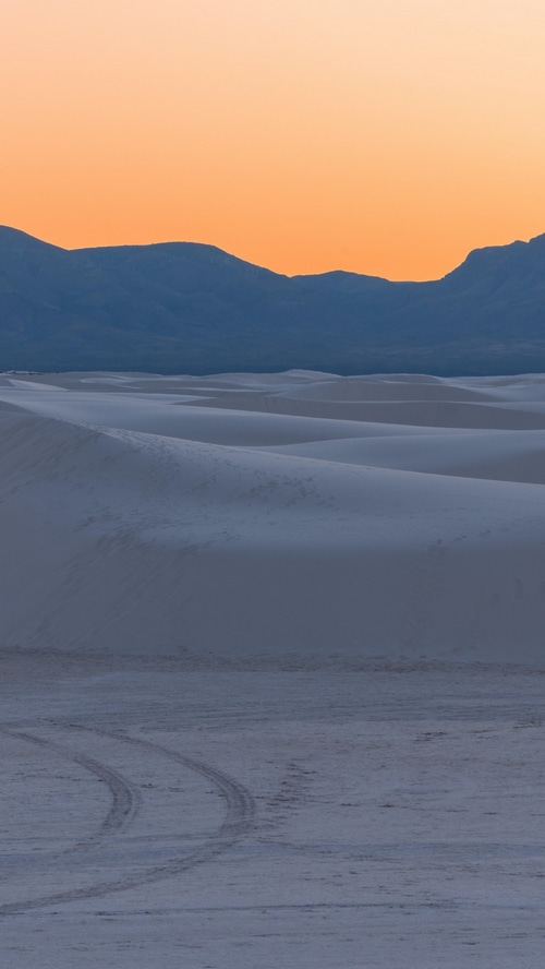 Sand dunes at sunset with mountains in the background