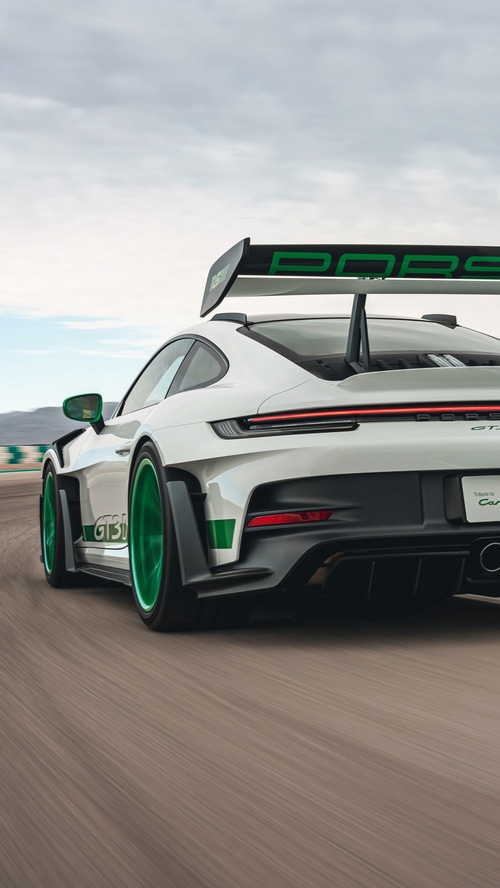 White Porsche 911 GT3 RS with green accents on a track