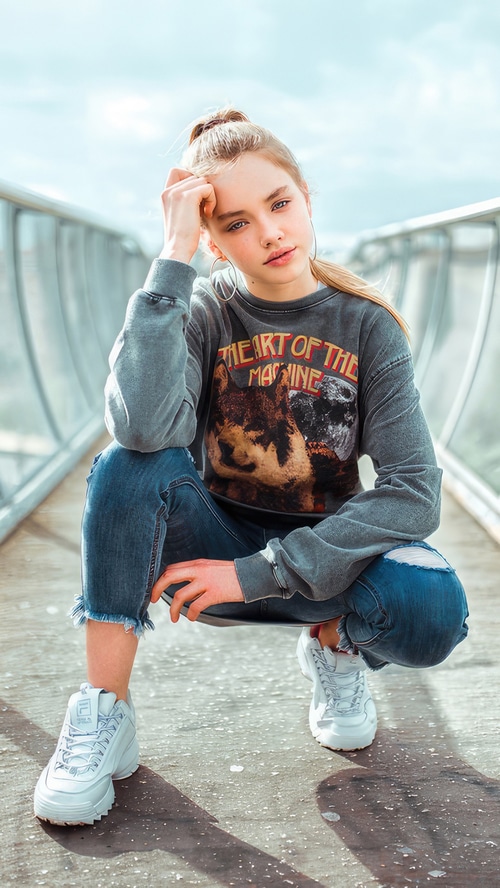 Young blonde girl in a sweatshirt and jeans