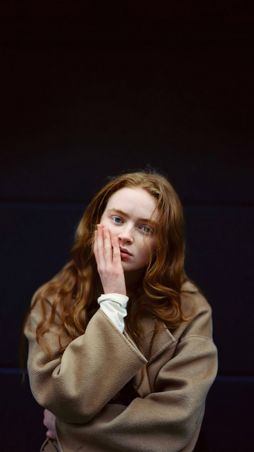 Sadie Sink with hand on face