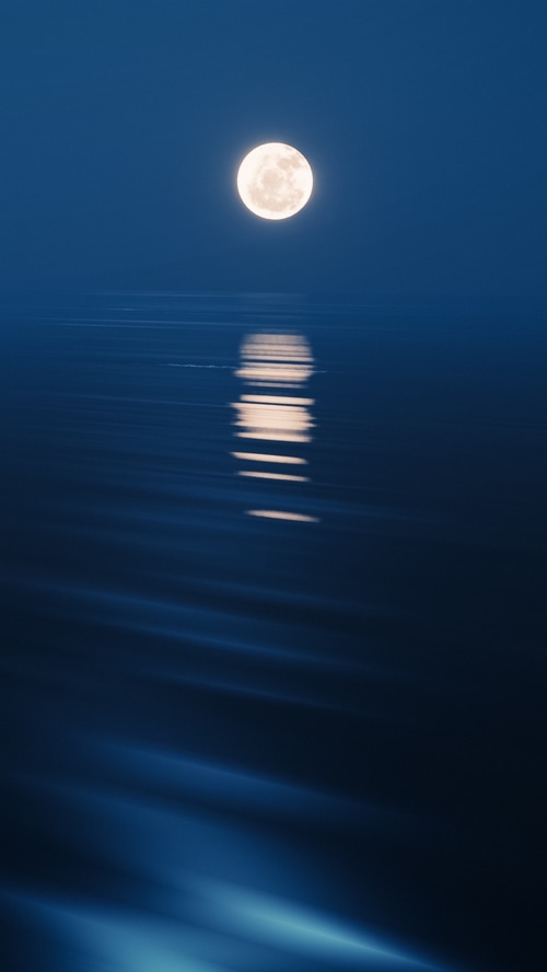 Full moon over the ocean at night