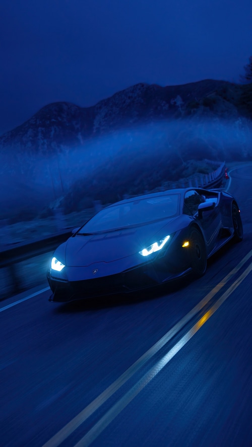 Lamborghini Aventador driving on a mountain road at night