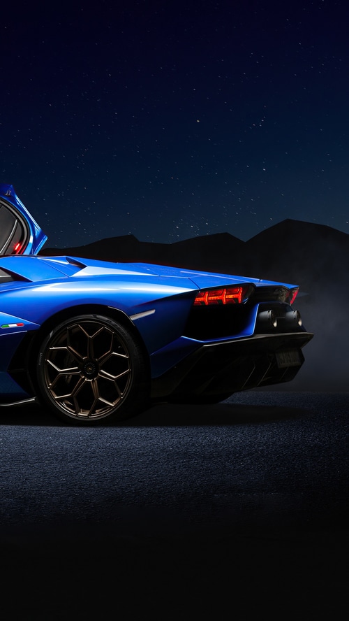 Blue Lamborghini Aventador parked under starry night sky