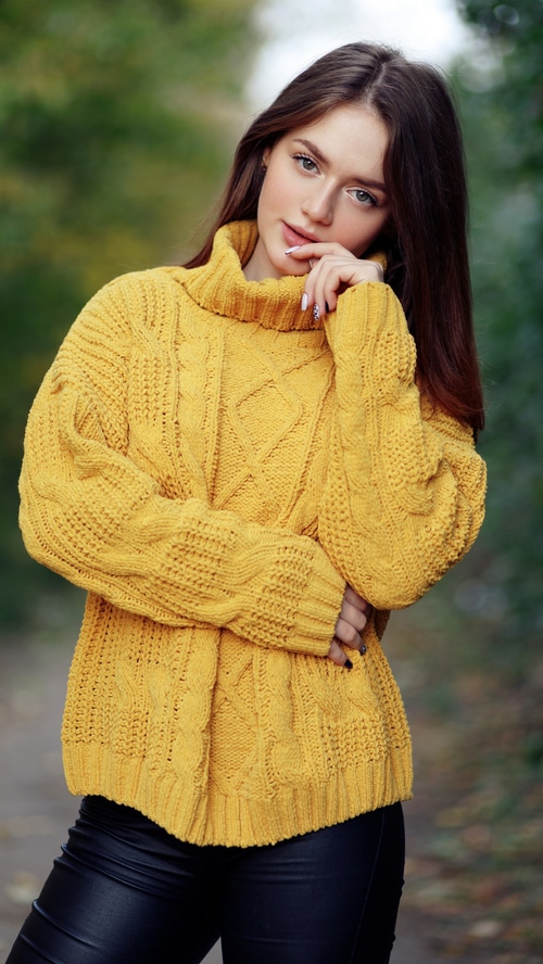 Young woman in a yellow sweater outdoors