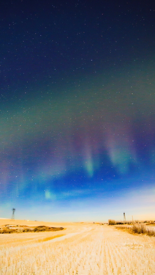 Aurora Borealis over a snowy field at night
