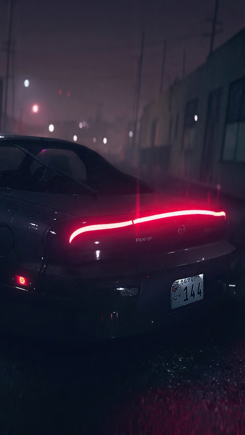 Mazda RX-7 in a rainy city at night
