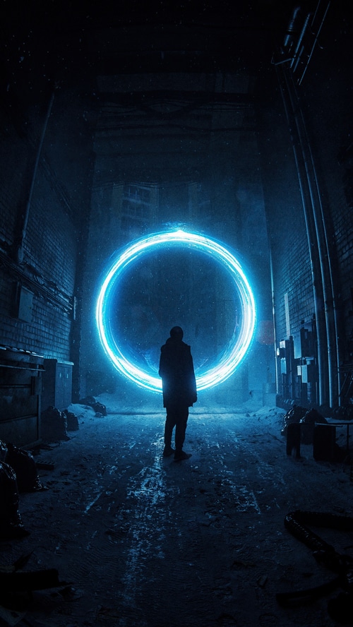 Man stands before a glowing blue portal in a dark alley