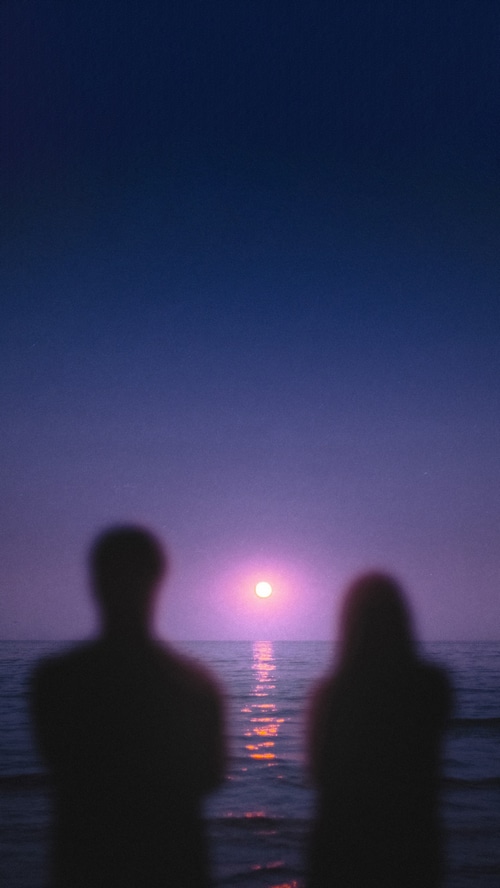 Couple watching the sunset over the ocean