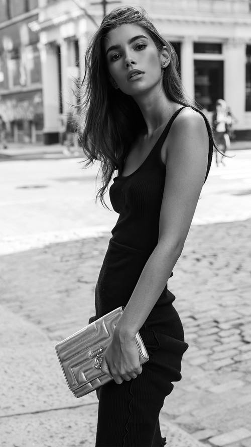 Cindy Mello in a black dress holding a clutch