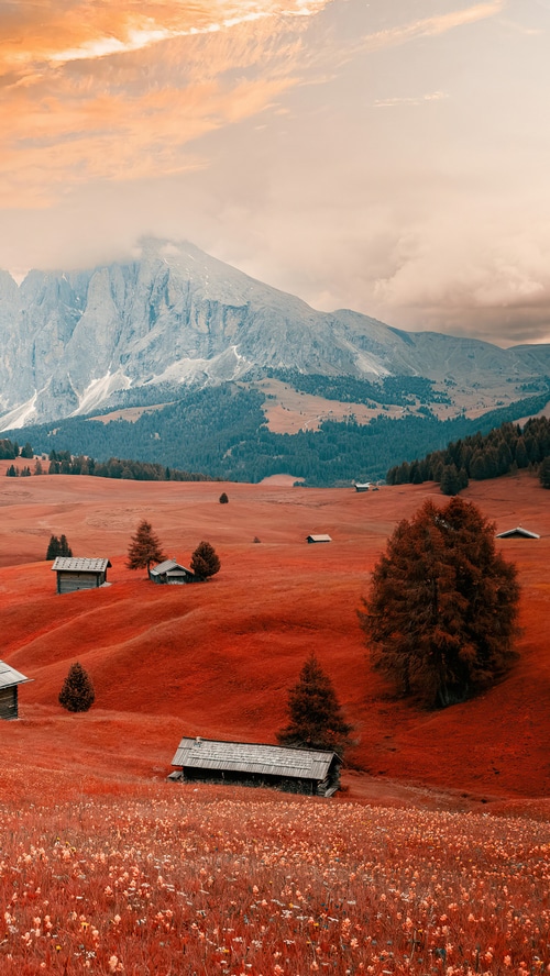 Dolomites Mountains in Italy with Red Grass and Cabins