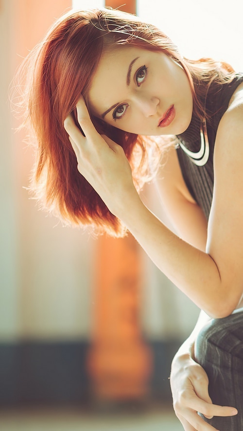Redhead girl posing with hand in hair