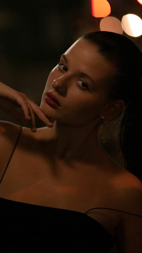 Model in a black dress with bokeh lights