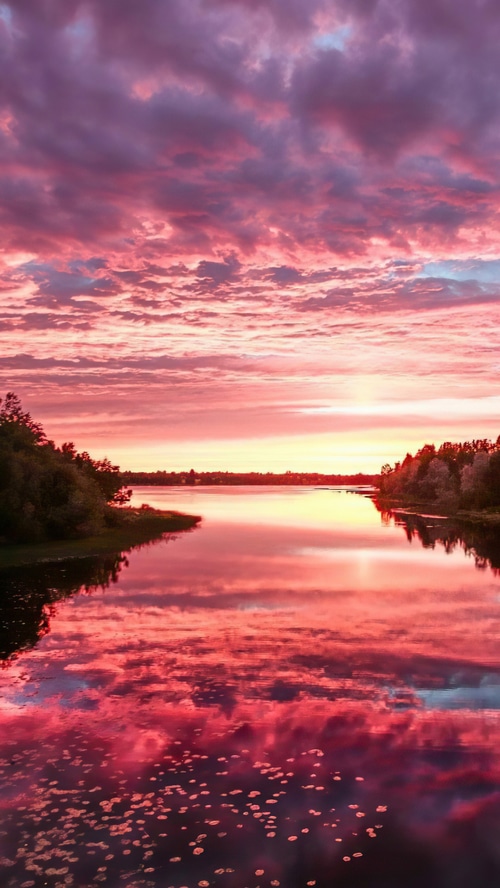 Pink and purple clouds over a lake at sunset