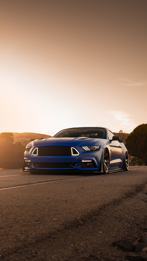 Blue Ford Mustang on a Road at Sunset