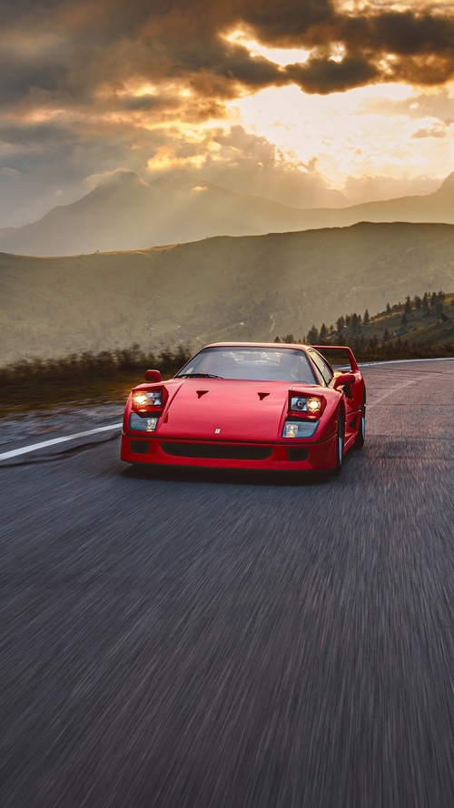 Red Ferrari F40 driving on a mountain road