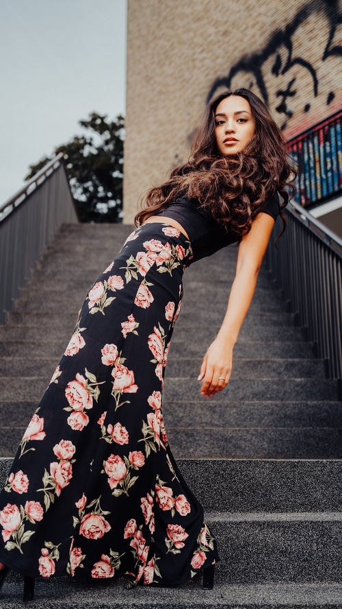 Young woman in a floral skirt on stairs