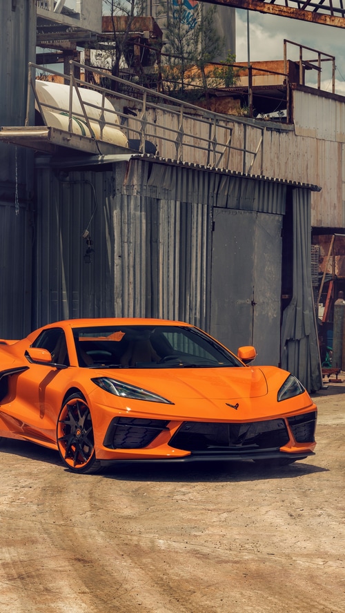 Orange Chevrolet Corvette C8 in an industrial setting