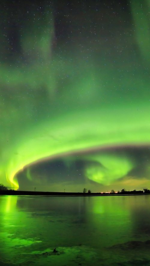 Aurora Borealis over a reflective body of water