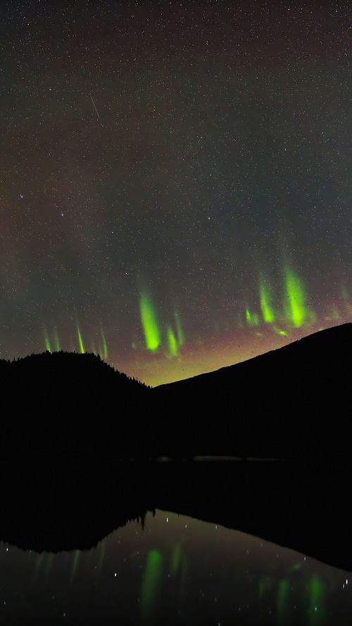 Aurora Borealis over a mountain lake in Canada