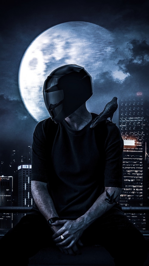 Biker with helmet and bird in front of moon and city