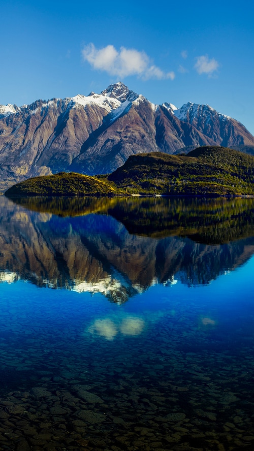 Snow-capped mountains reflected in a clear lake