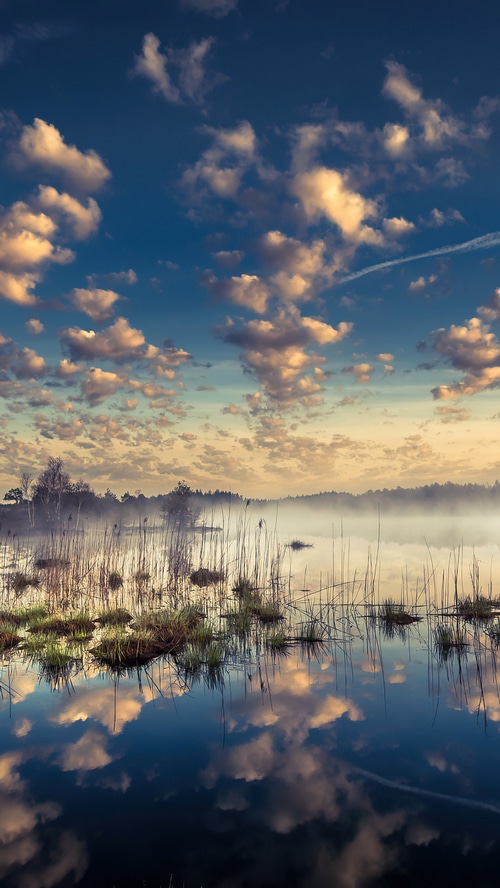 Misty lake with clouds reflected in the water
