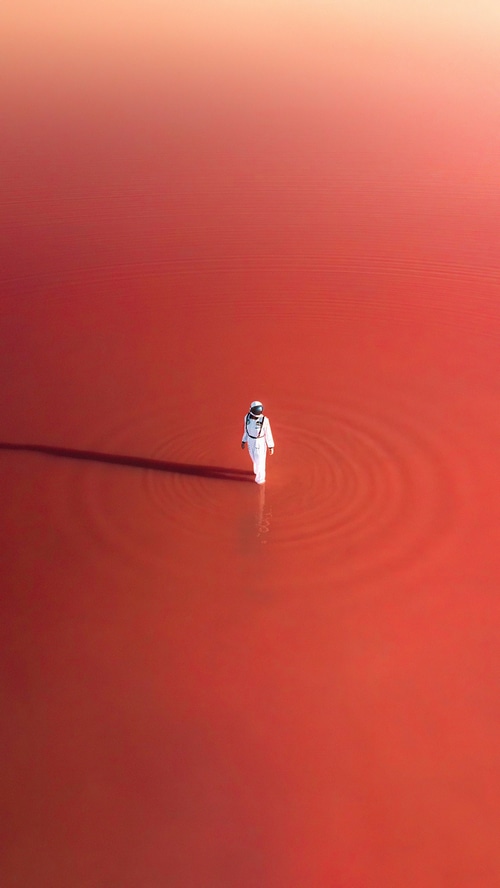 Astronaut walking in a red body of water