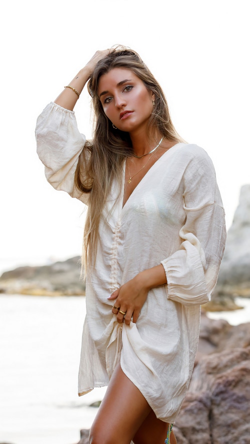 Woman in a white dress on a rocky beach