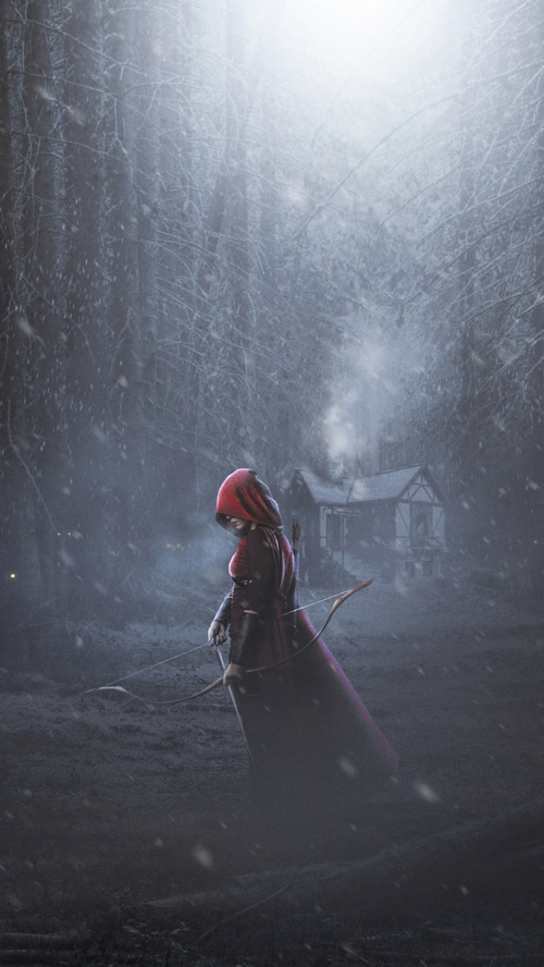 Warrior with bow in snowy forest near cabin