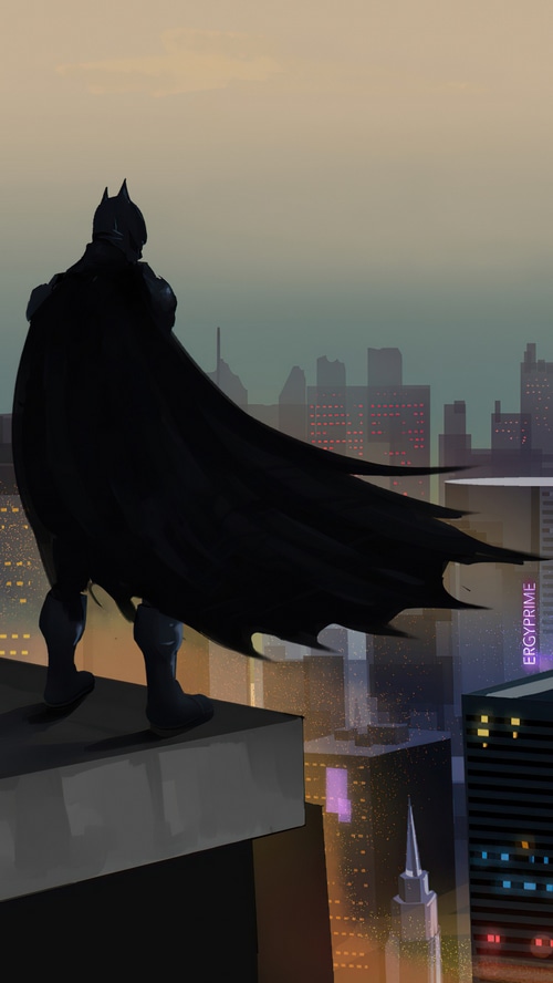 Batman overlooking a city at dusk