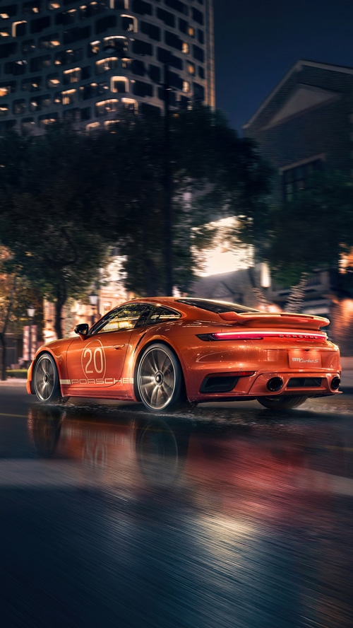 Orange Porsche 911 Turbo S on a wet street at night