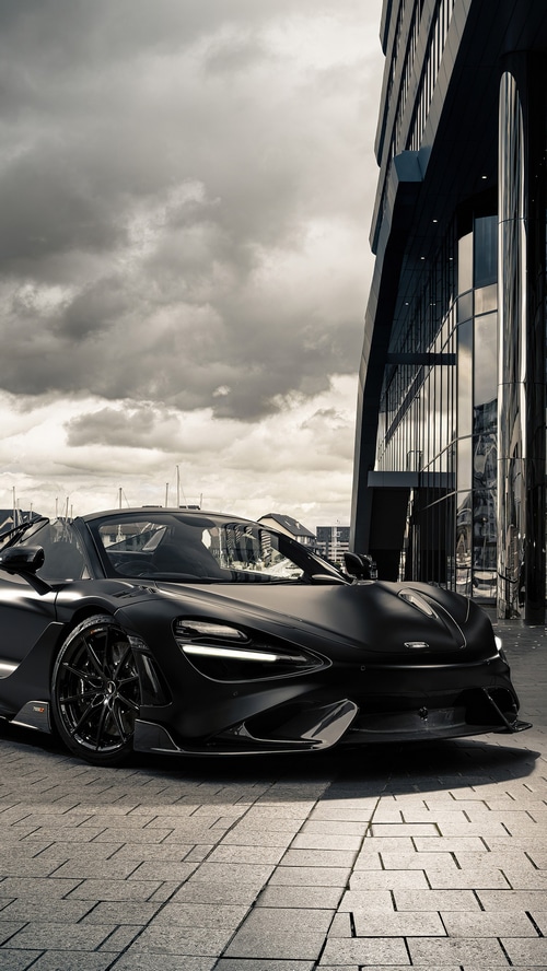 Matte black McLaren 765LT parked by a modern building