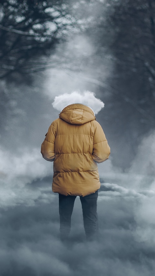 Person with a cloud over their head in a foggy forest