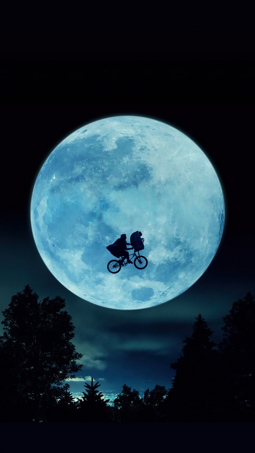 E.T. the Extra-Terrestrial flying on a bicycle in front of the moon
