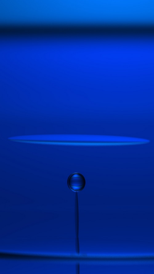 Water drop suspended in blue liquid