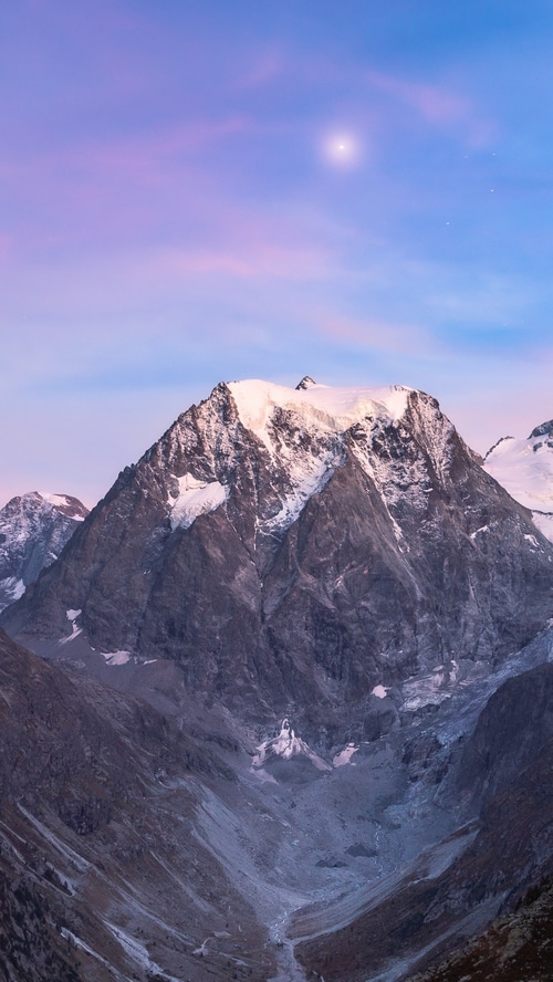 Snow-capped mountains under a twilight sky