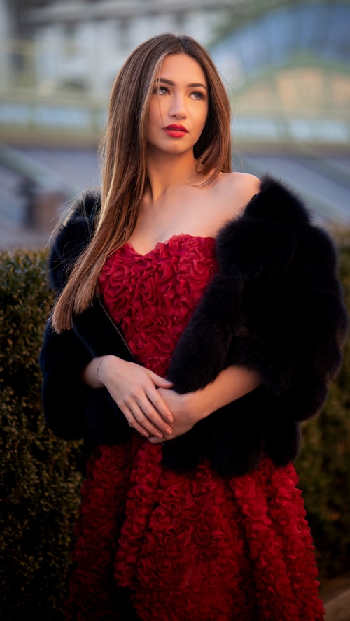 Woman in red dress and fur stole