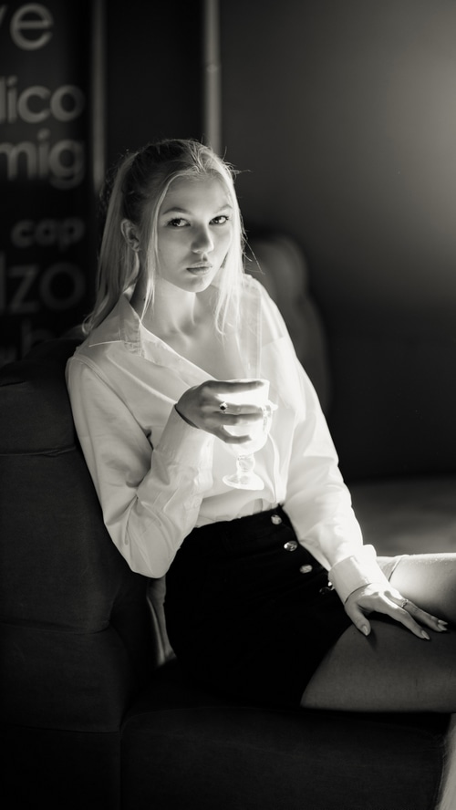 Monochrome portrait of a young woman holding a glass
