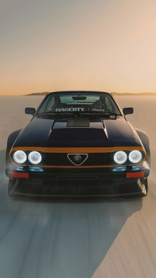 Alfa Romeo car on a salt flat at sunset