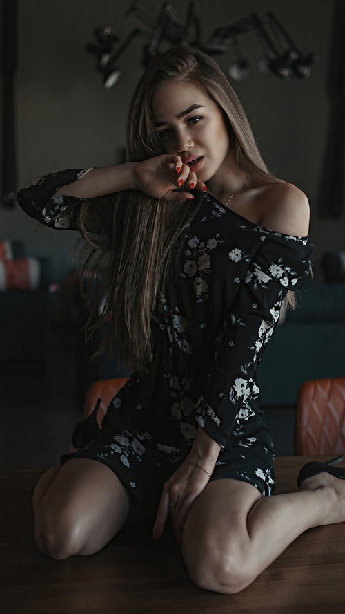 Woman in a floral dress posing on a table