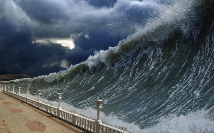 Massive wave crashes ashore under stormy skies