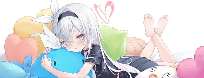 Plana hugging a blue whale plush toy with heart pillows