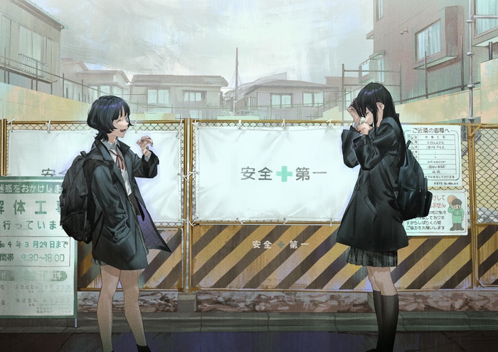 Two schoolgirls in front of a construction fence