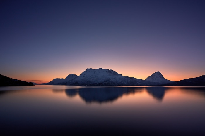 4K sunset over mountains reflected in water