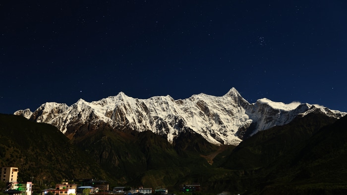 4K snowy mountains under a starry sky in Tibet at night