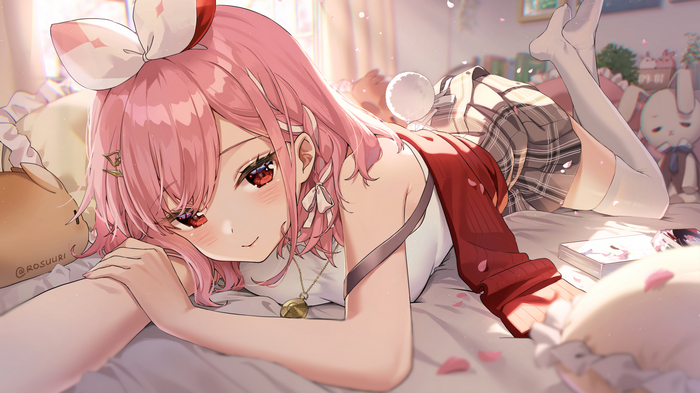 Girl with pink hair lying on a bed with pillows