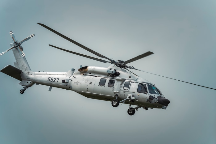 Gray military helicopter with number 6627 flying
