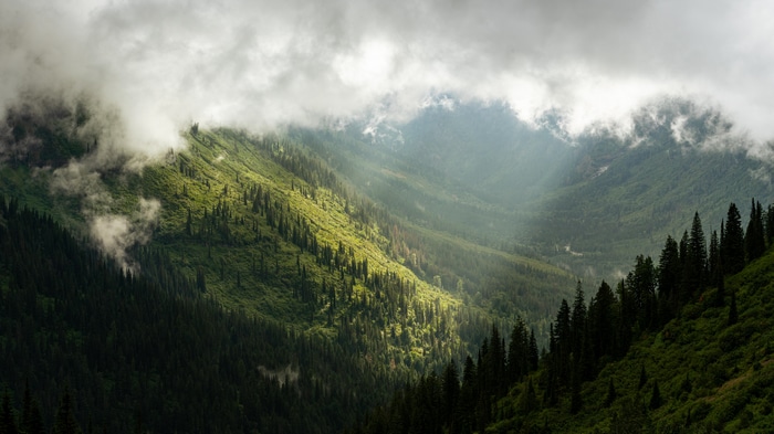 Sunlight through clouds over Rocky Mountains landscape