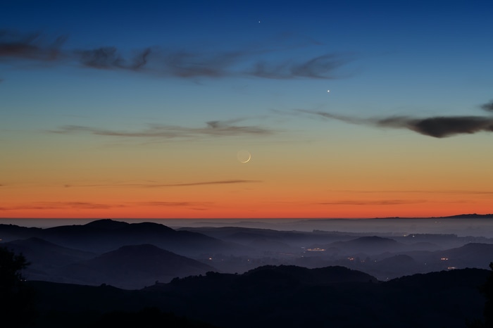 Crescent Moon and Planets over Mountains at Sunset